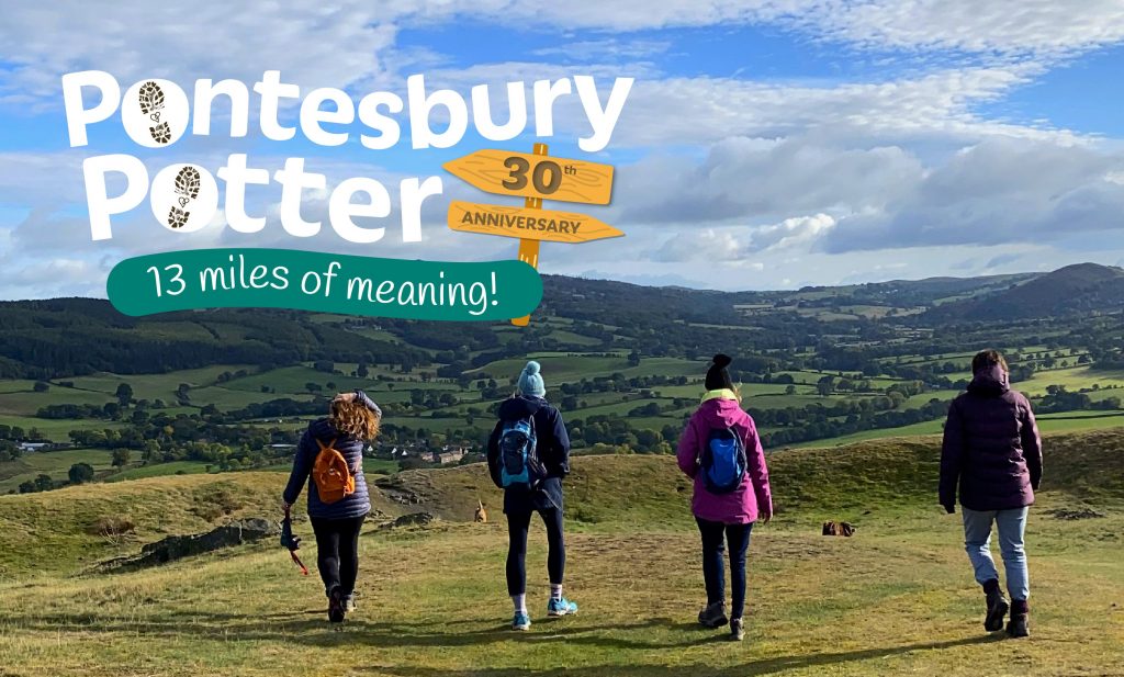 Four hill walkers taking a hike over a hill