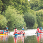 Three dragon boats racing on River Severn.
