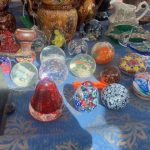 a bric-a-brac stall displaying paperweights and other items