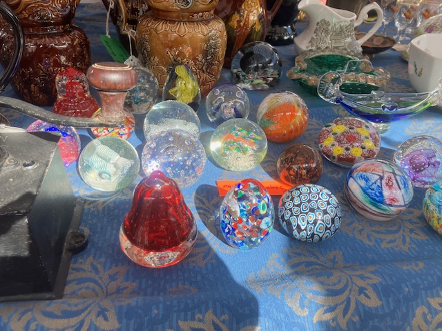 a bric-a-brac stall displaying paperweights and other items